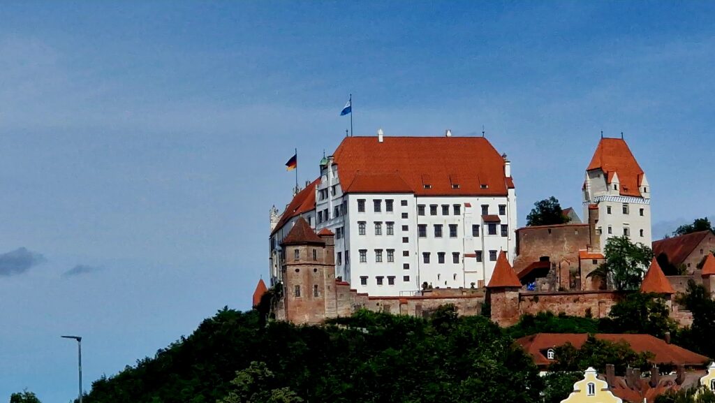 Schloss auf dem Hügel, mit Dachreiter und Flaggen.