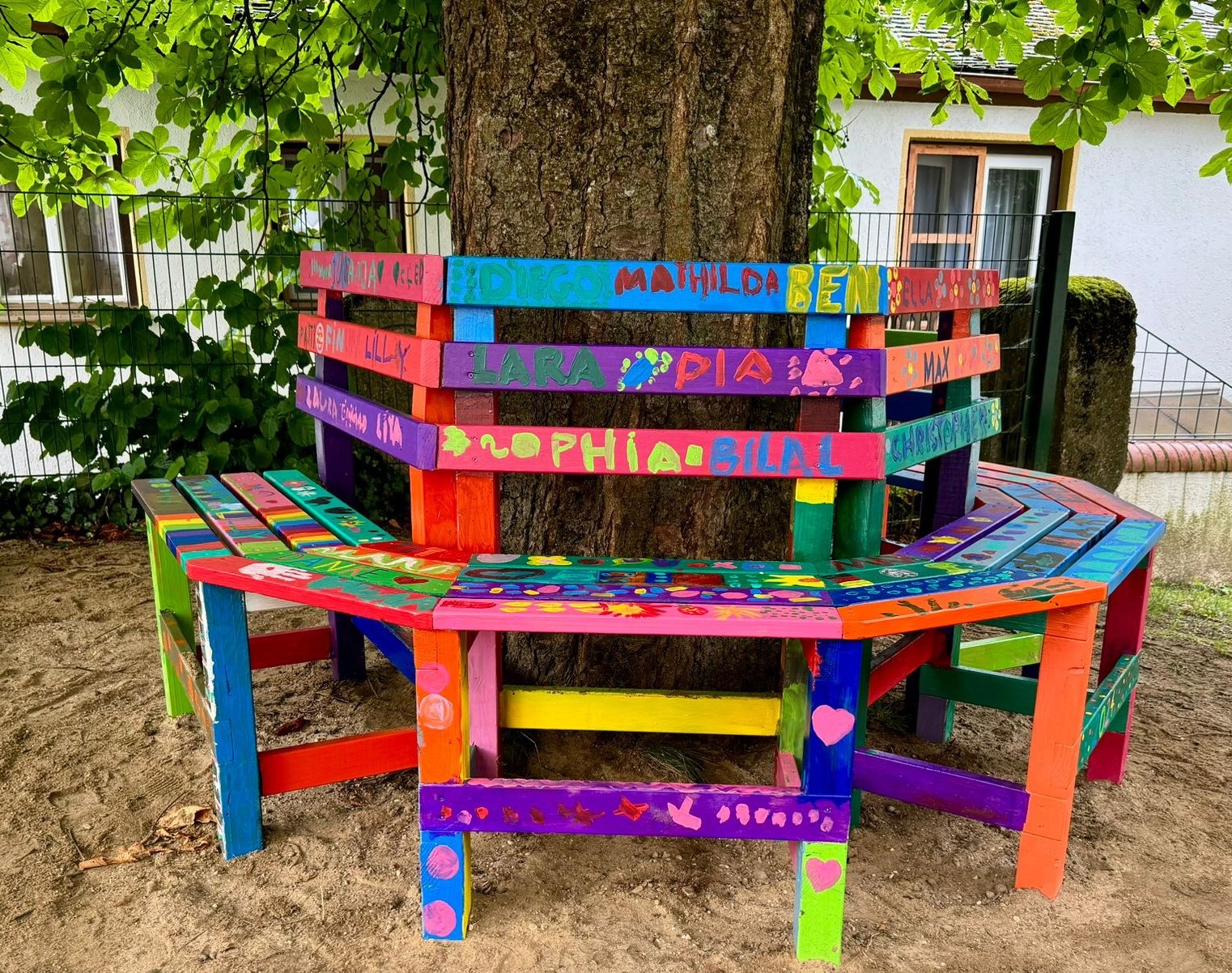 Leider haben wir keinen Titel zu diesem Bild. Wir arbeiten daran und bitten um Ihr Verständnis. farbige, benutzte Parkbank mit Namen von Kindern auf den Sitzplätzen.