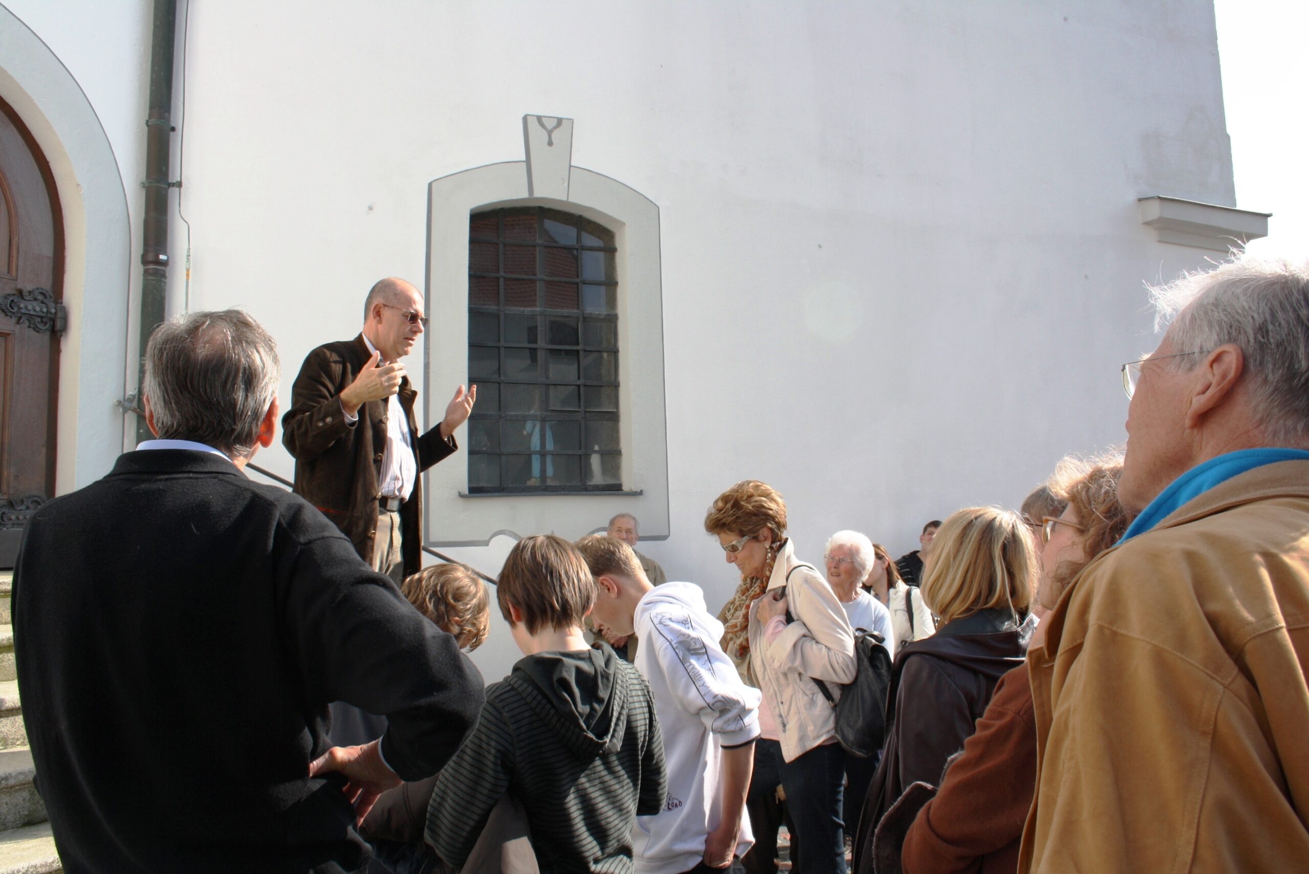 Gästeführung Ein Mann spricht vor einem Publikum auf einem Weg zum Markt in Altomünster.