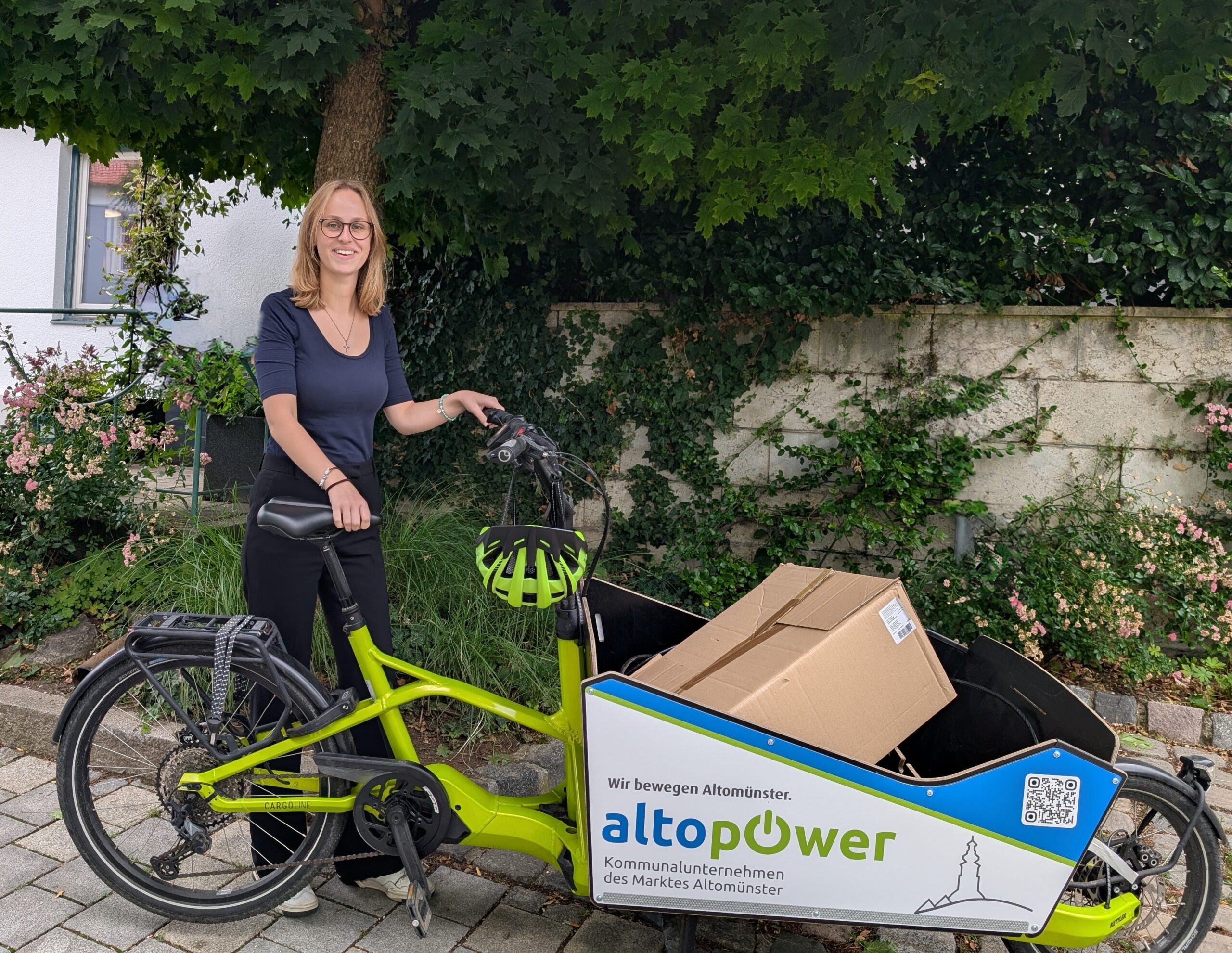 Leider haben wir keinen Titel zu diesem Bild. Wir arbeiten daran und bitten um Ihr Verständnis. Frau mit Elektrorad und Paket auf der Fahrt, Altomünster.