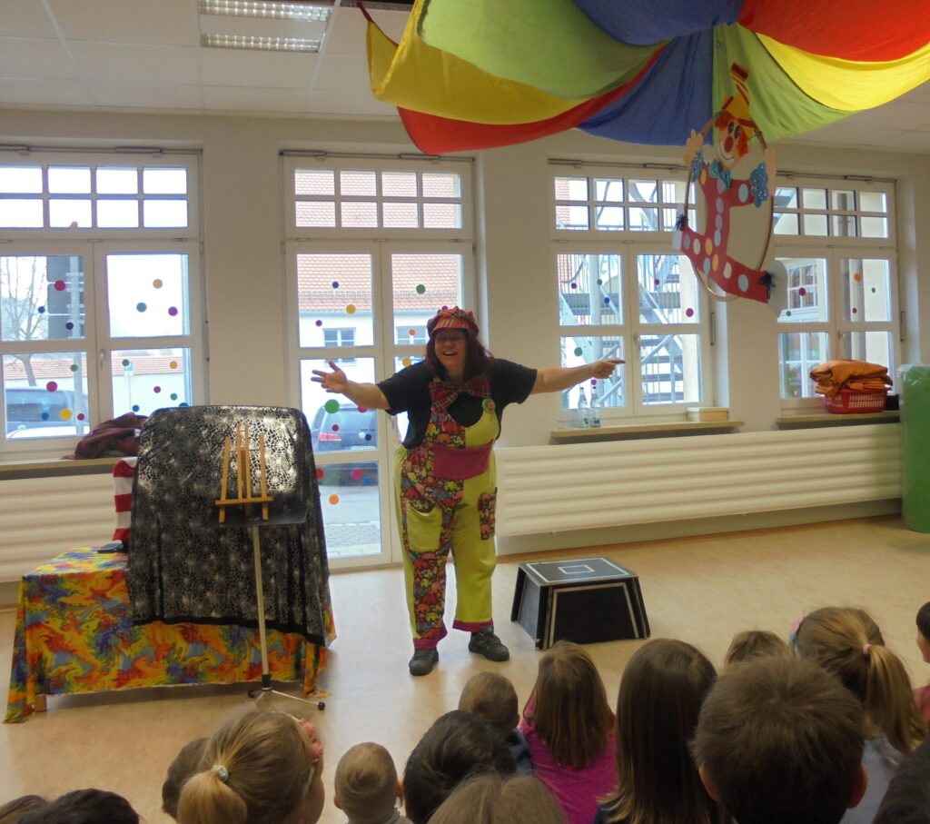 Kleinkunstlerin auf Bühne mit Kindern.